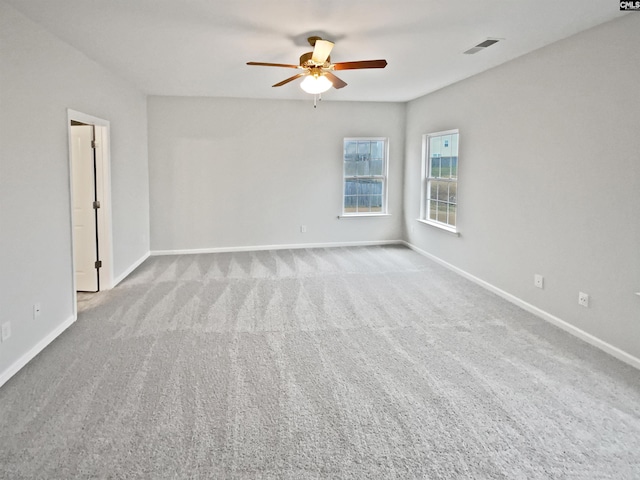 empty room featuring ceiling fan and light colored carpet