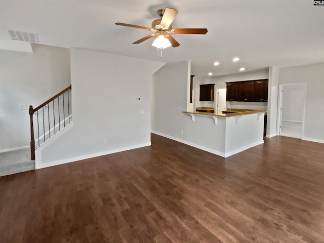 unfurnished living room featuring dark hardwood / wood-style floors and ceiling fan