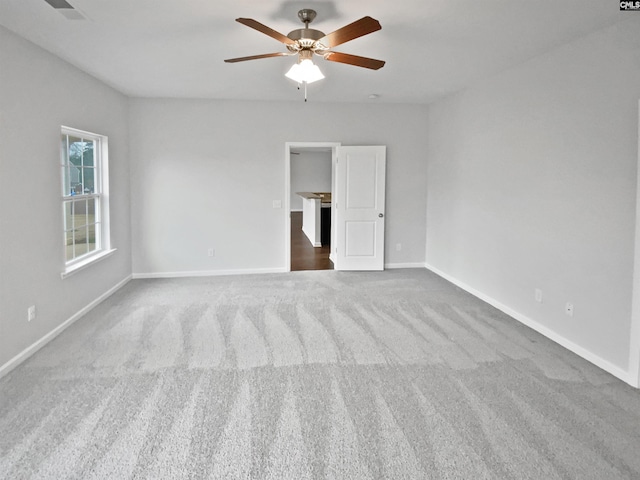 carpeted spare room featuring ceiling fan