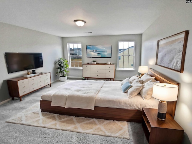 bedroom featuring light carpet and multiple windows