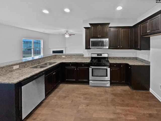 kitchen featuring ceiling fan, dark brown cabinetry, appliances with stainless steel finishes, and hardwood / wood-style floors