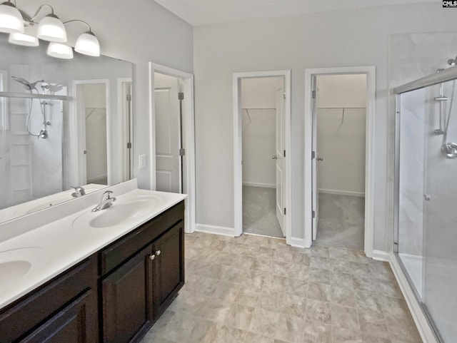 bathroom featuring a shower with door and vanity