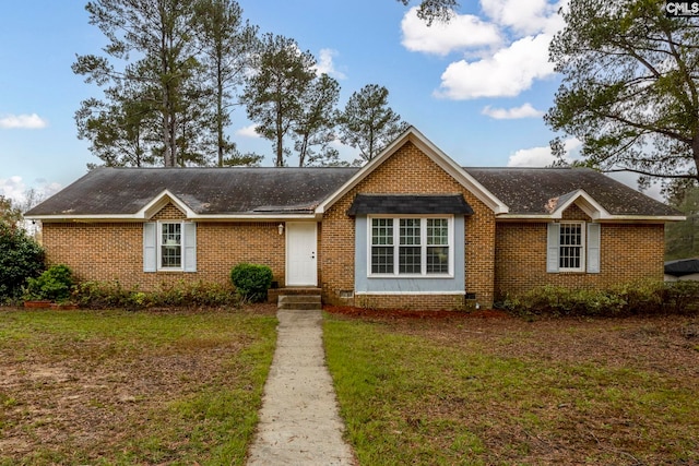 ranch-style house featuring brick siding and a front yard