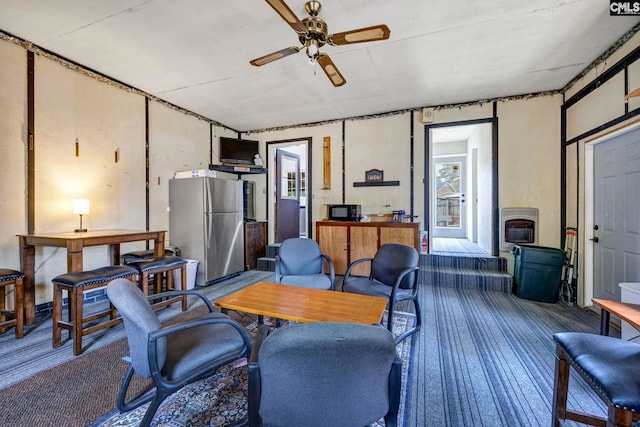 living room with hardwood / wood-style floors, heating unit, and ceiling fan