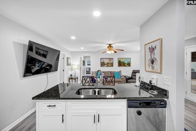 kitchen featuring white cabinetry, stainless steel dishwasher, and dark stone counters