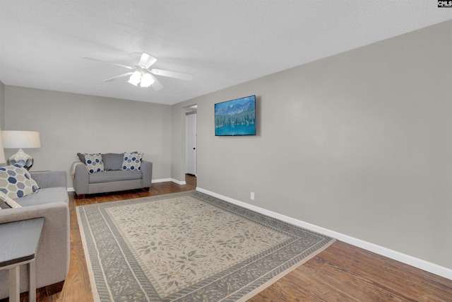 living room featuring hardwood / wood-style floors, a textured ceiling, and ceiling fan