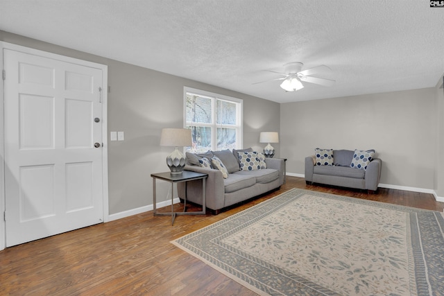 living room featuring wood-type flooring, a textured ceiling, and ceiling fan