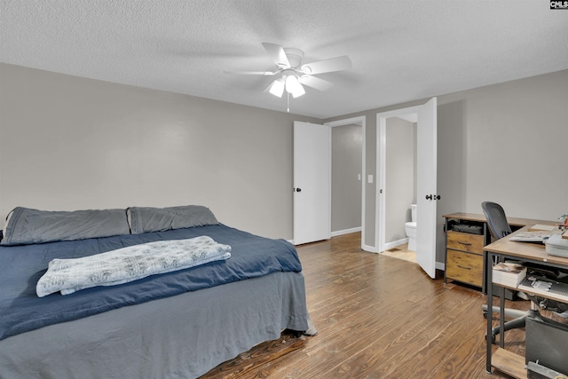 bedroom featuring dark wood-type flooring, ceiling fan, connected bathroom, and a textured ceiling