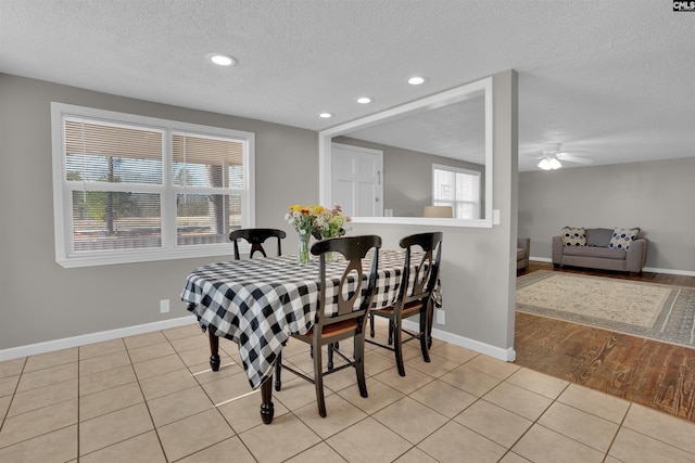 dining room featuring ceiling fan, a healthy amount of sunlight, light tile patterned floors, and a textured ceiling