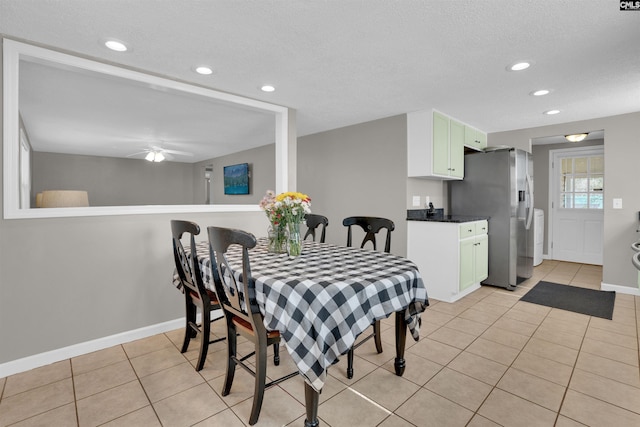 tiled dining area featuring a textured ceiling and ceiling fan