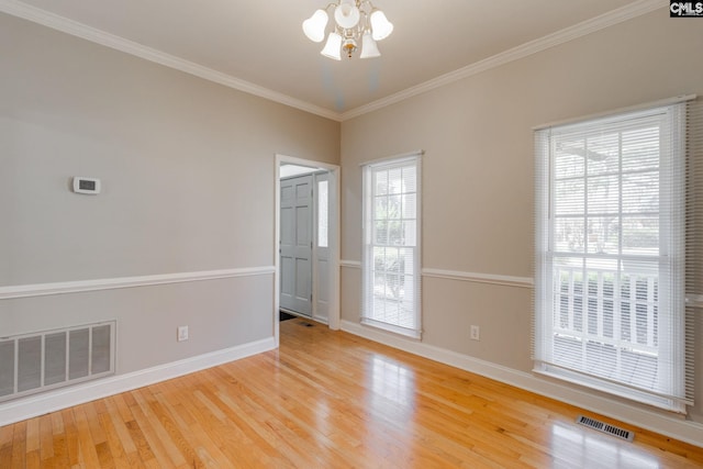 unfurnished room with ornamental molding, wood-type flooring, and a chandelier