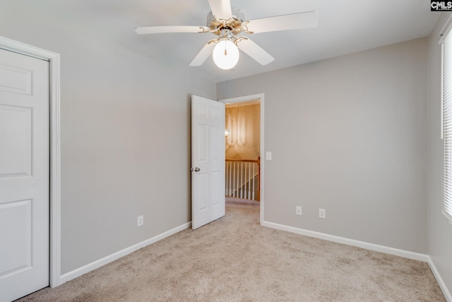 unfurnished bedroom featuring light carpet and ceiling fan