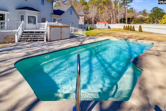 view of pool with a shed, a yard, and a deck