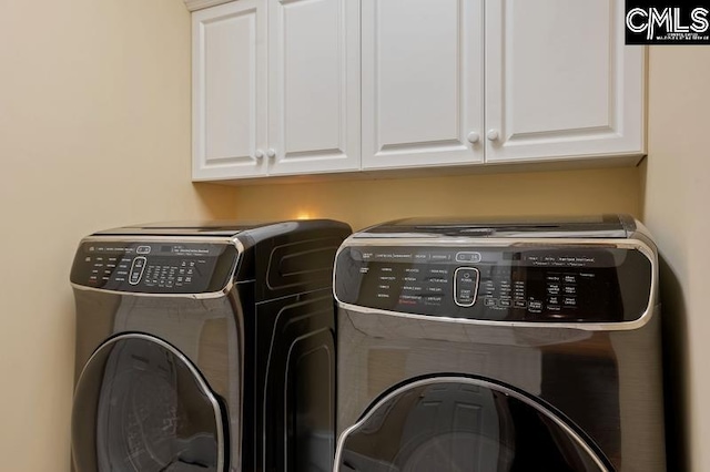 laundry room featuring cabinets and washing machine and dryer