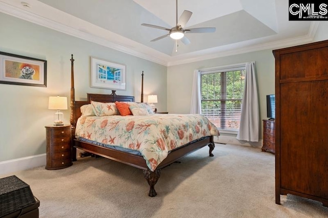 carpeted bedroom featuring a tray ceiling, ornamental molding, and ceiling fan