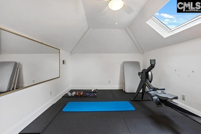 workout room featuring ceiling fan and vaulted ceiling with skylight