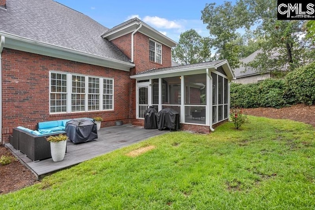 back of property with a patio, a sunroom, and a lawn