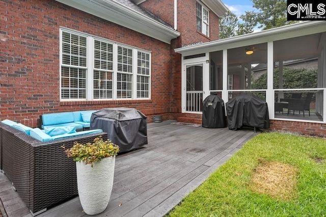 wooden deck with grilling area, a sunroom, and a lawn