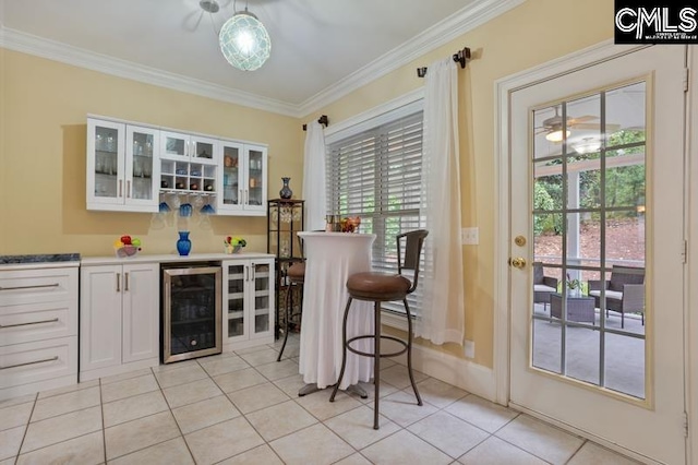 bar featuring white cabinetry, light tile patterned floors, beverage cooler, and crown molding