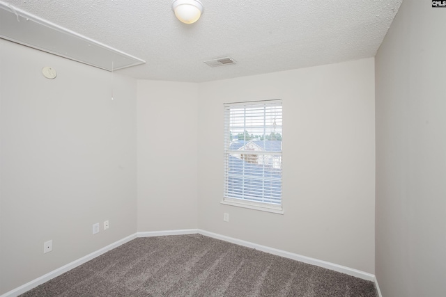 empty room with carpet floors and a textured ceiling