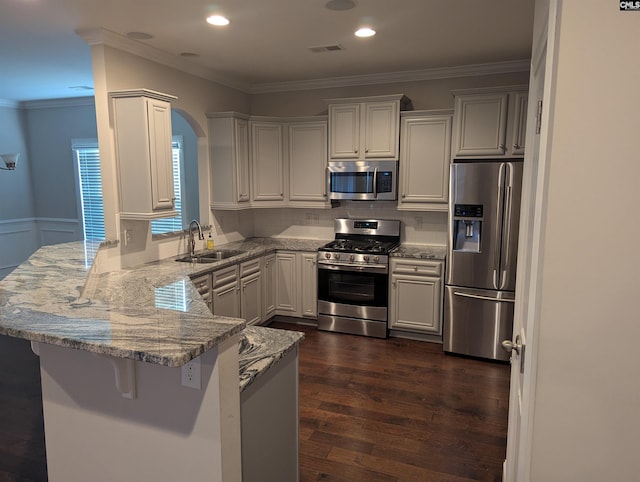 kitchen featuring stainless steel appliances, sink, a breakfast bar area, and kitchen peninsula