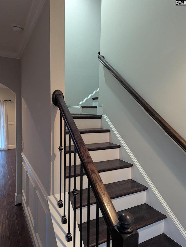 stairs featuring crown molding and hardwood / wood-style flooring