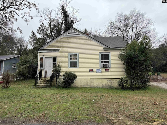 view of front of home with a front yard and cooling unit