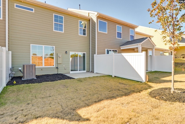 rear view of house featuring a patio, a lawn, and central air condition unit