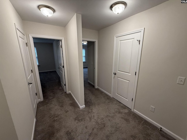 hallway featuring dark carpet