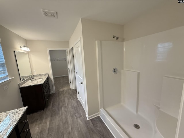 bathroom featuring a shower, vanity, and wood-type flooring