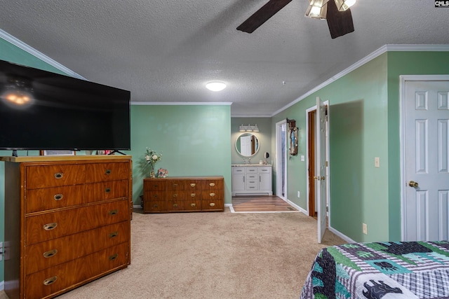 carpeted bedroom with crown molding, ensuite bath, ceiling fan, and a textured ceiling