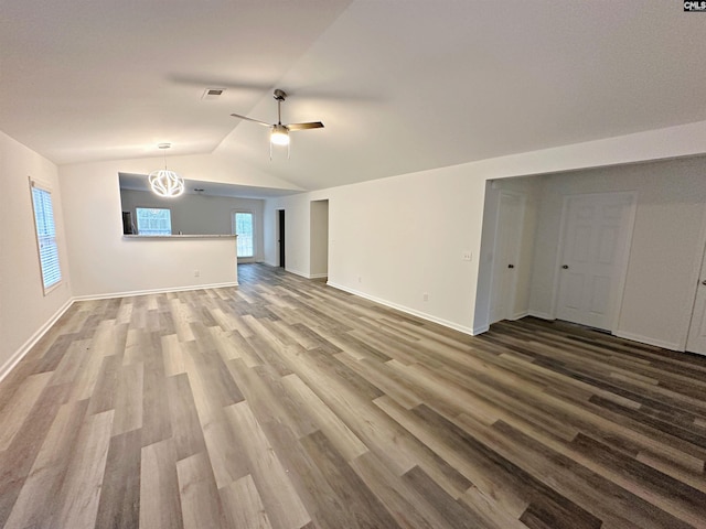 unfurnished living room featuring vaulted ceiling, hardwood / wood-style floors, and ceiling fan