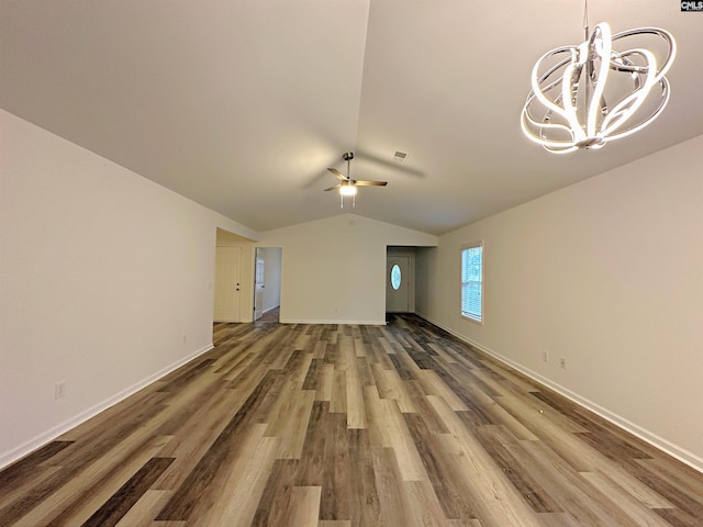 unfurnished living room with lofted ceiling, hardwood / wood-style floors, and ceiling fan with notable chandelier