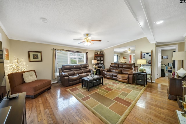 living room featuring hardwood / wood-style flooring, ornamental molding, ceiling fan, and a textured ceiling