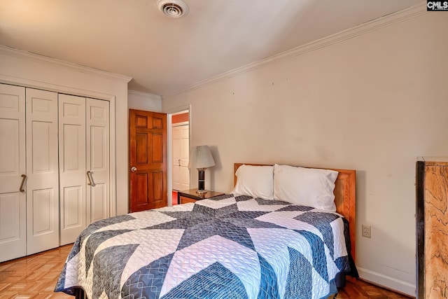 bedroom with parquet flooring, ornamental molding, and a closet