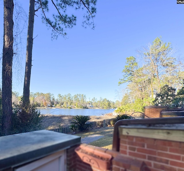 exterior space featuring a water view and a covered hot tub