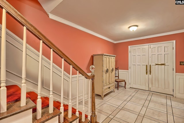 foyer featuring ornamental molding and light tile patterned flooring