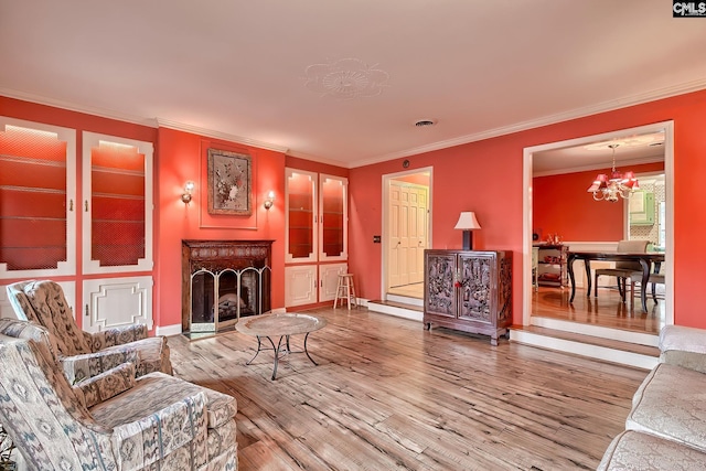 living room featuring crown molding, hardwood / wood-style floors, and a chandelier