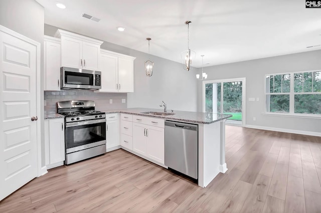 kitchen with kitchen peninsula, white cabinets, and appliances with stainless steel finishes