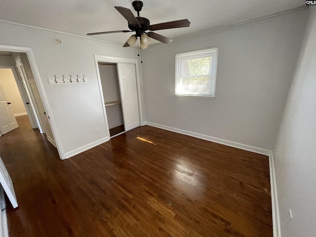 unfurnished bedroom with ceiling fan, dark hardwood / wood-style flooring, and a closet