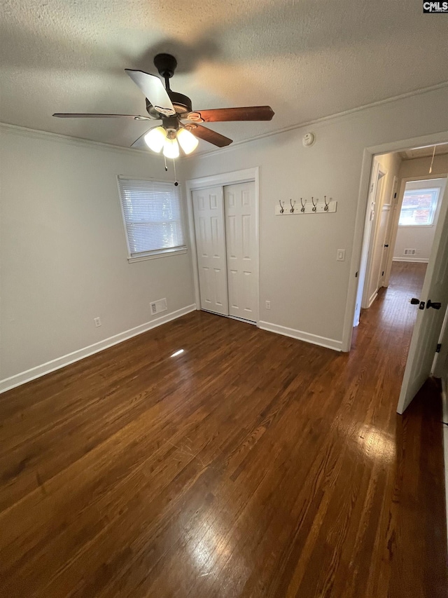 unfurnished bedroom with a closet, dark hardwood / wood-style floors, a textured ceiling, and ceiling fan