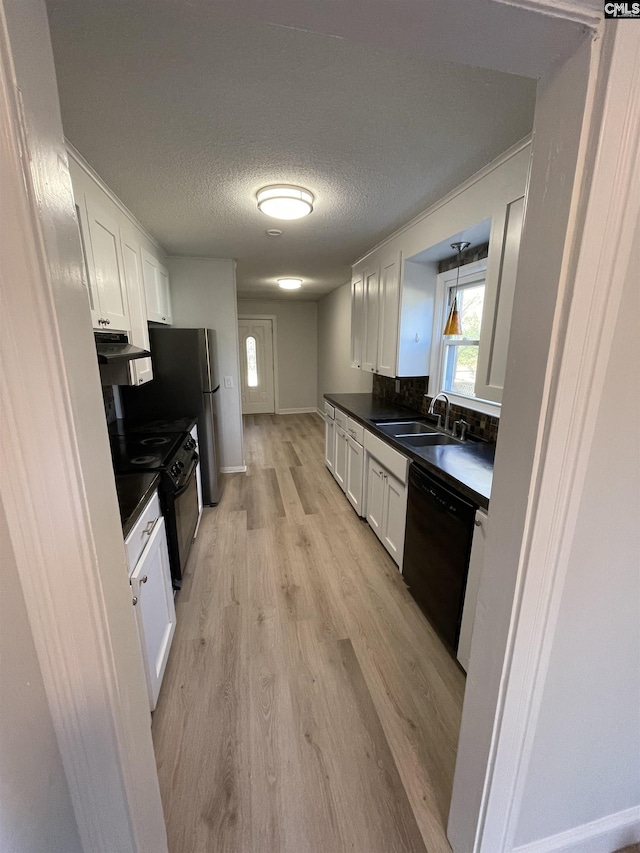 kitchen with sink, white cabinets, light hardwood / wood-style floors, black appliances, and a textured ceiling