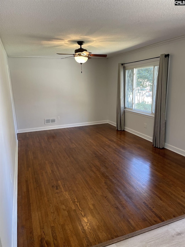 spare room featuring dark wood-type flooring, ceiling fan, and a textured ceiling