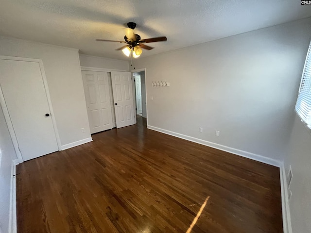 unfurnished bedroom featuring a textured ceiling, dark hardwood / wood-style floors, and ceiling fan