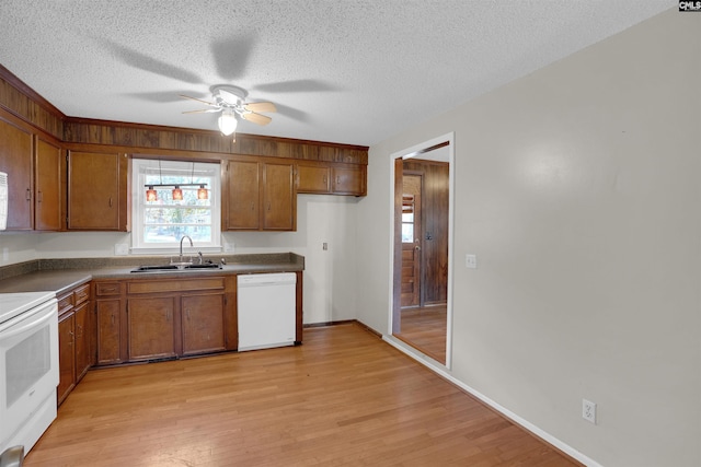 kitchen with white appliances, light hardwood / wood-style floors, sink, and a textured ceiling