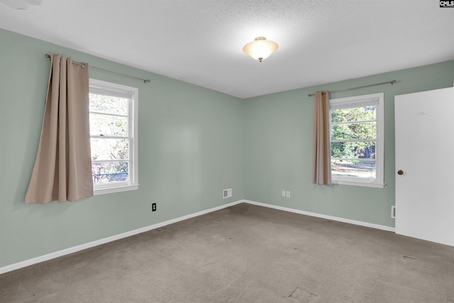 carpeted spare room with a textured ceiling