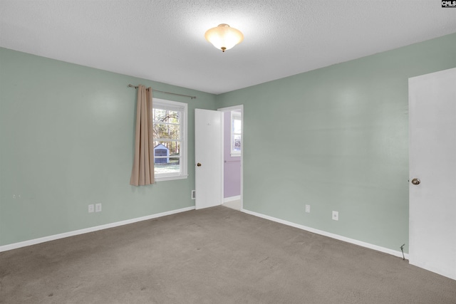 unfurnished room featuring carpet flooring and a textured ceiling