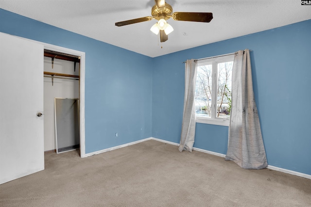 unfurnished bedroom featuring light carpet, a closet, and ceiling fan