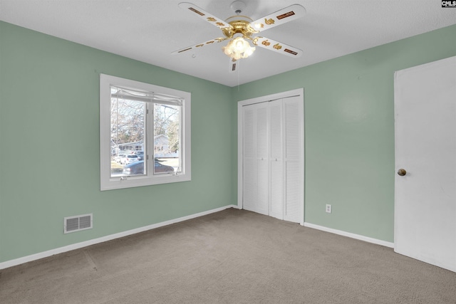 unfurnished bedroom with a closet, ceiling fan, and carpet flooring