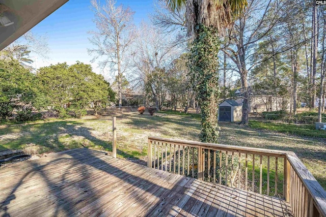 wooden terrace featuring a yard and a shed